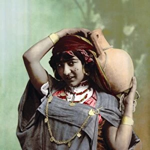 TUNISIA: BEDOUIN WOMAN. A Tunisian Bedouin woman carrying a jug. Photochrome, c1899