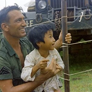 VIETNAM WAR, 1967. Sergeant Hugh Maple playing with a Vietnamese child. Photograph