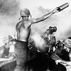 VIETNAM WAR: ARTILLERY. An American artilleryman discards a spent shell casing, ejected from a 105mm Howitzer in the central highlands of South Vietnam, March 1967