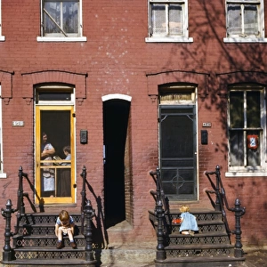 WASHINGTON D. C. : HOUSES. Children playing on the steps of row houses in Washington, D