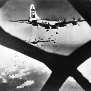 WORLD WAR II: B-29, 1945. Incendiary bombs from two Boeing B-29 Superfortresses drop on a Japanese target. Photograph, 16 July 1945, through the nose of a Superfortress