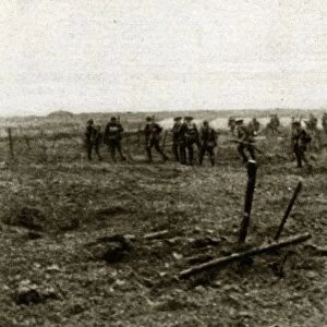WWI: YPRES, 1917. Canadian troops advancing through German entanglements on a battlefield