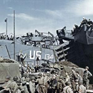 WWII: D-DAY, 1944. American troops loading a tank landing ship in a British port town