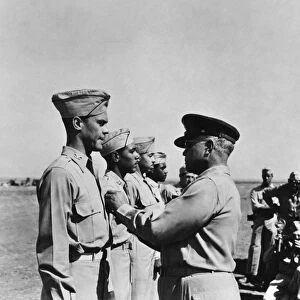 WWII: FLYING CROSS AWARDS. Brigadier General Benjamin Oliver Davis, Sr. pins the Distinguished Flying Cross on his son, Benjamin O. Davis, Jr. while Joseph Elsberry, Jack Holsclaw, Clarence Lester await their turn, in Italy, 1944