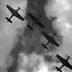 WWII: P-51 MUSTANGS, 1945. Four P-51 Mustang fighter planes flying in formation over Ramitelli