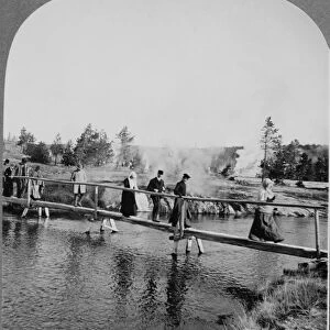 YELLOWSTONE: TOURISTS, c1904. Tourists walking across a footbridge among the geysers