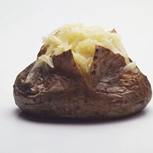 A baked potato topped with grated cheese