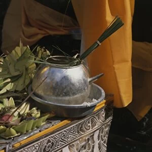 Bali, pot of holy water next to offerings at a temple