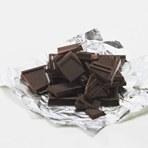 Broken squares of dark chocolate on piece of foil