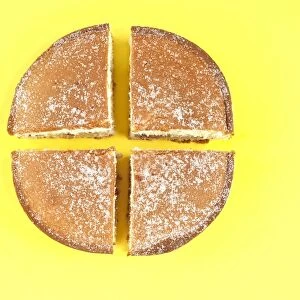 Cake cut into four quarters, on yellow background