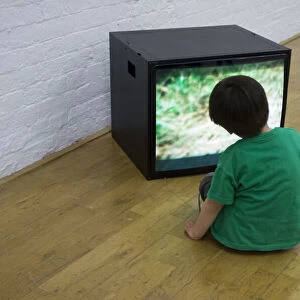Child watching TV-based art installation in an Oxfordallery