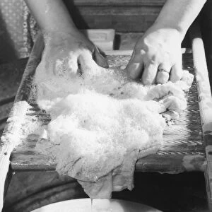 Close-up of woman washing clothes on washboard