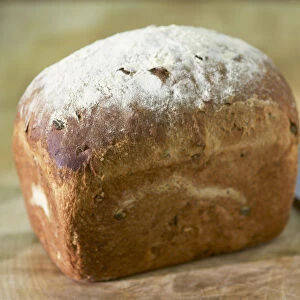 Home-baked, crusty loaf of bread with knife, close-up