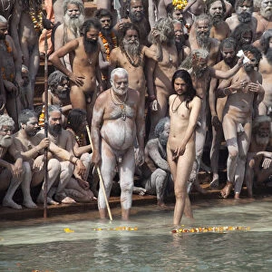 Naga sadhus on Har-ki-Pauri ghat about to take a dip in the river Ganges on the occasion of Somvati Amavasya, a no moon day in the traditional Hindu calendar