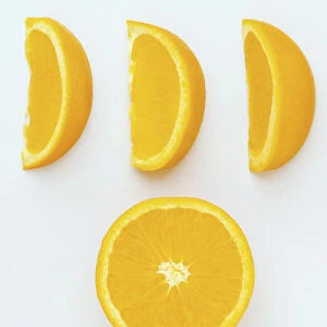 An orange cut in half and three segments