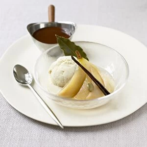 Pears with ice cream and chocolate sauce served in glass bowl on white plate