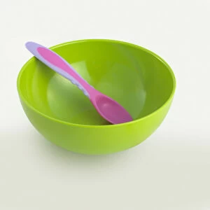 Pink spoon in bright green plastic bowl