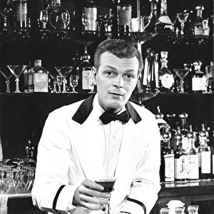 Portrait of a bartender holding a drink
