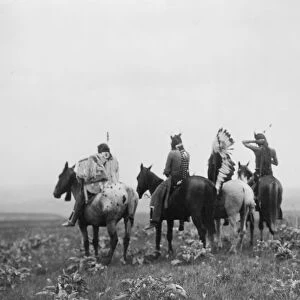 Rear view of four Crow Indians, including Shot in the Hand and Bull Chief, on horseback