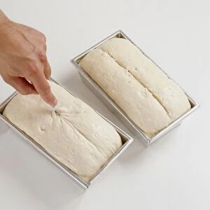 Slashing dough in loaf tin with a scalpel, close-up