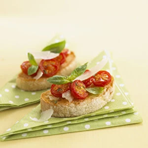 Tomato bruschetta with parmesan shavings and basil leaves, close-up