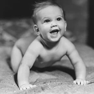 Baby (6-9 months) crawling on blanket, looking up (B&W)