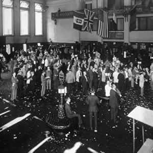 circa 1918: Businessmen crowd the floor of the New York Stock Exchange