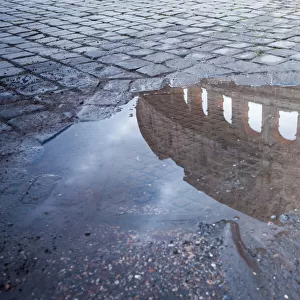 Colosseum reflected in puddle, Rome, Italy