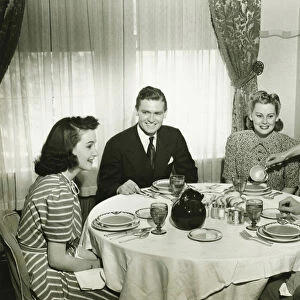 Two couples having dinner, maid pouring soup, (B&W)