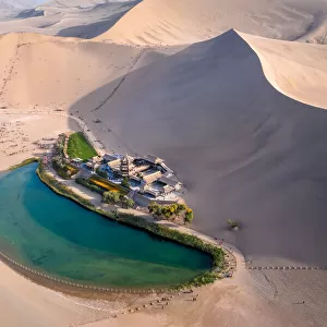 Crescent Lake with buddhist temple in Kumtag desert, Dunhuang, Gansu China
