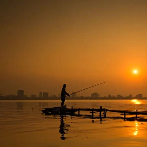 Fisherman fishing on Hanoi West Lake on sunset, Vietnam