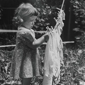GIRL PINS LAUNDRY TO CLOTHESLINE, 1944