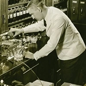 Male pharmacist working in laboratory, (B&W), (Elevated view)