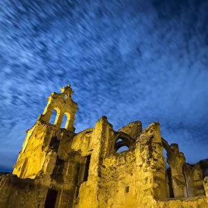 Ruins of abandoned convent one night with blue sky and the full moon