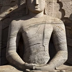 Statue of a sitting Buddha attached to the rock