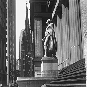 Statue at steps in front of building, Wall Street, Trinity Church in distance, New York City, USA (B&W)