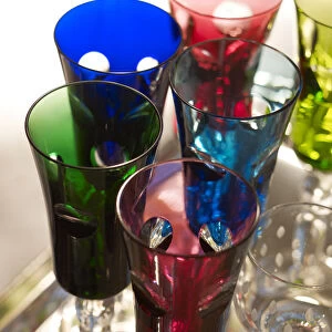 Stylish, colourful tinted champagne glasses on a silver platter