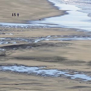 White Cliffs Beach at low tide, three men walking in the distance, rocks in the surf, Ahititi, Taranaki, North Island, New Zealand