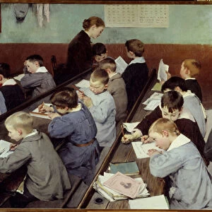 In class, the work of the little ones. Young boys in school blouse study in a classroom