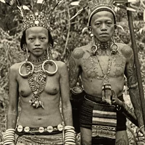 Dayak couple in traditional dress and tattoos, c. 1920 (b / w photo)
