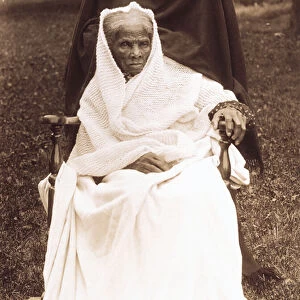 Harriet Tubman, full-length portrait, seated in chair, facing front, probably at her home in Auburn, New York, 1911 (b&w photo)