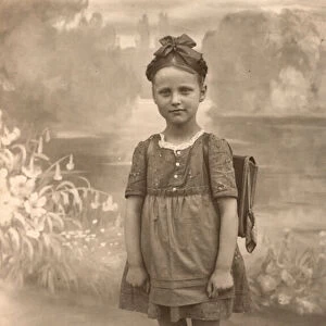 Studio portrait of young girl, wearing her school satchel (b / w photo)