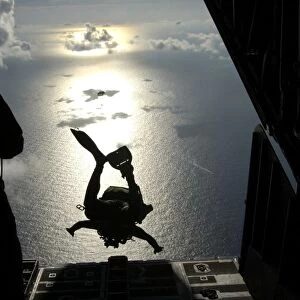 An Air Force pararescueman jumps out of the back of an HC-130 Hercules
