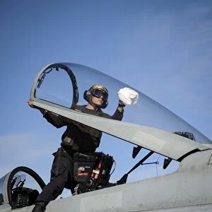 Airman cleans the canopy of an F / A-18C Hornet