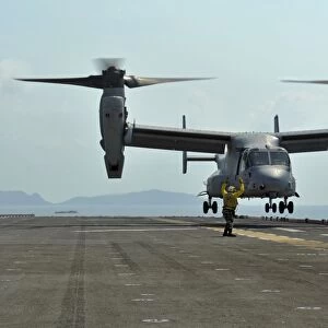 Aviation Boatswains Mate signals an MV-22 Osprey as it takes off