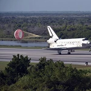 With drag chute unfurled, space shuttle Discovery lands on Runway 33 at the Shuttle