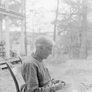An elder woman cutting fruit on a farm near Bulls Gap, Tennessee, 1933
