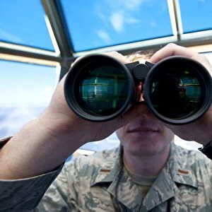 Lieutenant uses binoculars to scan the flightline at Holloman Air Force Base