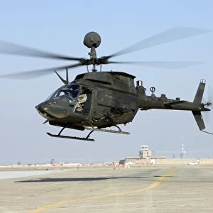 An OH-58D Kiowa Warrior hovers over the flight line at Camp Speicher, Iraq