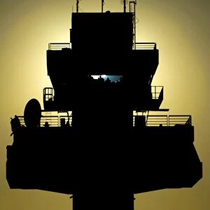 The setting sun silhouettes an air traffic control tower